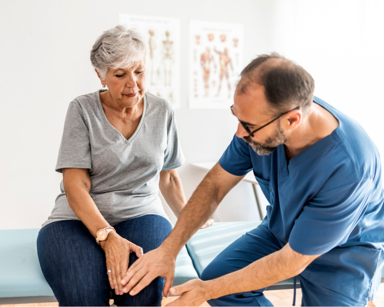 doctor helping older lady with knee pain